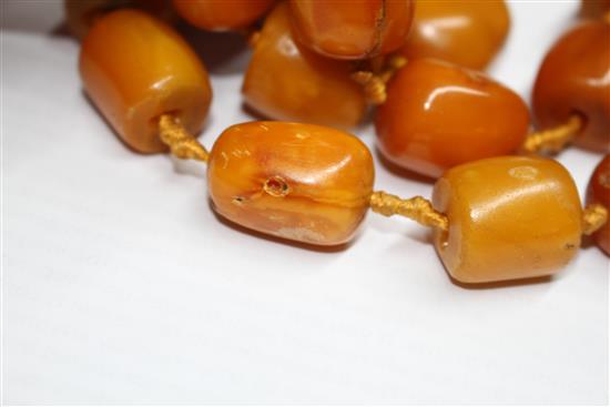 A single strand barrel shaped amber bead necklace, 86cm.